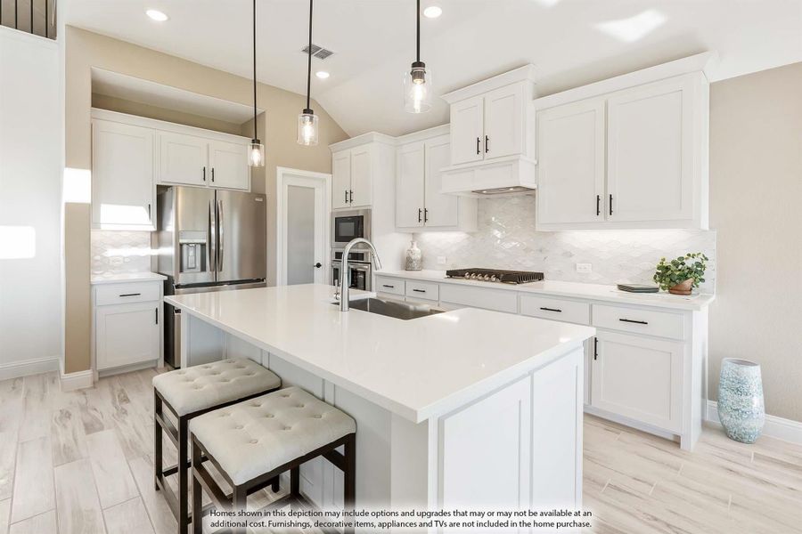 Kitchen with white cabinets, large center island, pendant lights, and stainless steel appliances on light wood floors Kitchen with white cabinets, large center island, pendant lights, and stainless steel appliances on light wood floors