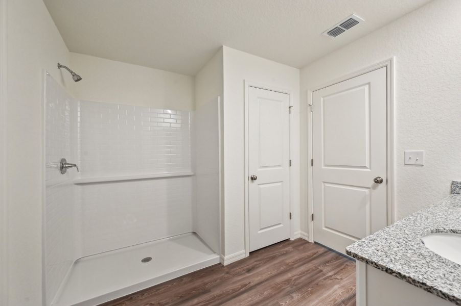 A bathroom with white cabinets.