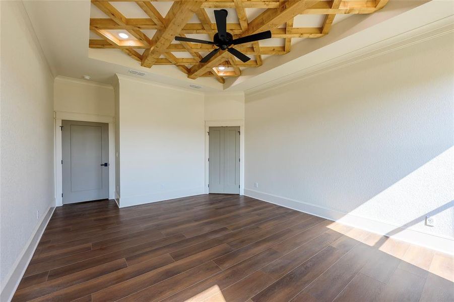 Unfurnished room featuring coffered ceiling, dark wood finished floors, and a ceiling fan