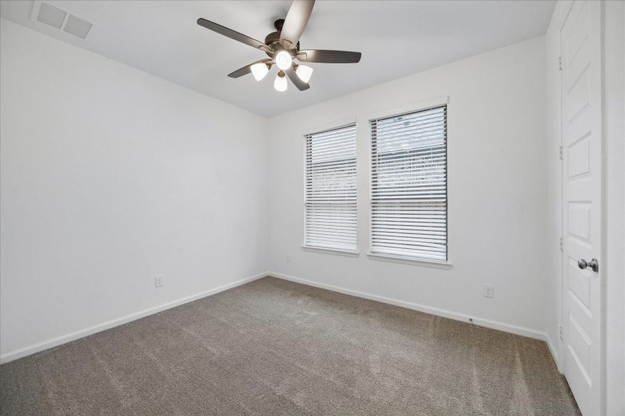 The 1st -floor secondary bedroom offers great flexibility with soft neutral carpet, a cooling fan, a large walk-in closet, and a nearby full bathroom. It’s a comfortable space for guests, a hobby room, home gym, or whatever fits your lifestyle.