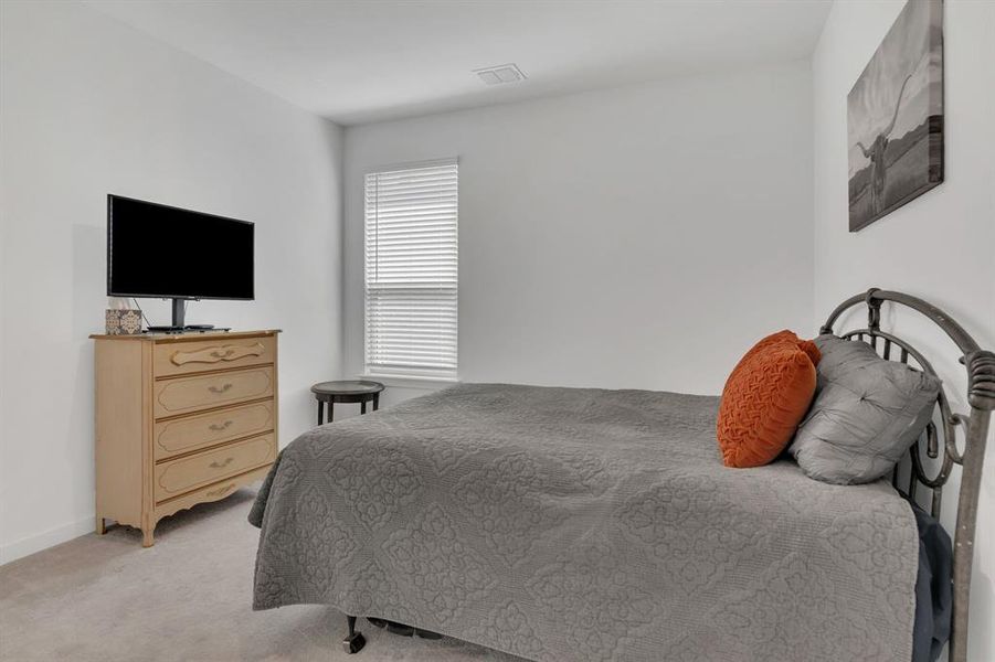 Bedroom featuring light carpet