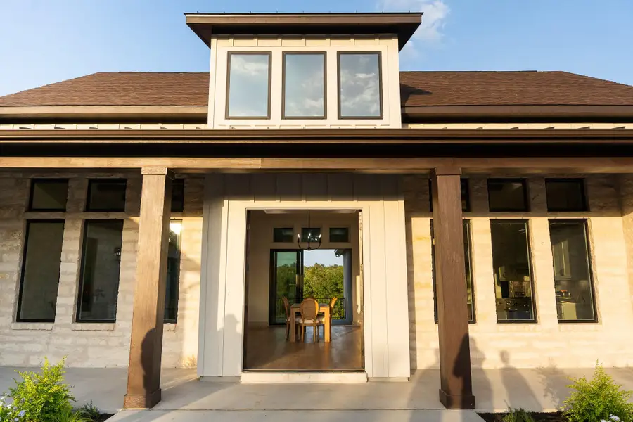 Property entrance with roof with shingles and covered porch Property entrance with roof with shingles and covered porch