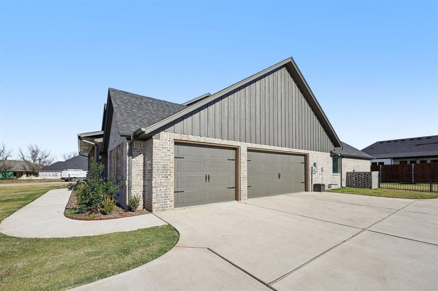 View of home's exterior with brick siding, driveway, a garage, and a shingled roof View of home's exterior with brick siding, driveway, a garage, and a shingled roof