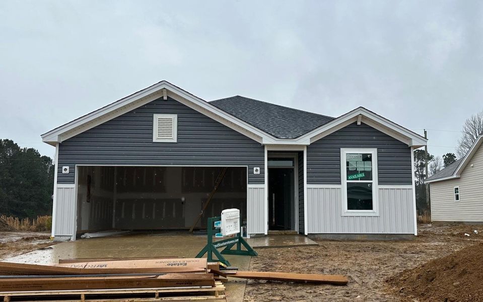 Property under construction featuring concrete driveway and a garage