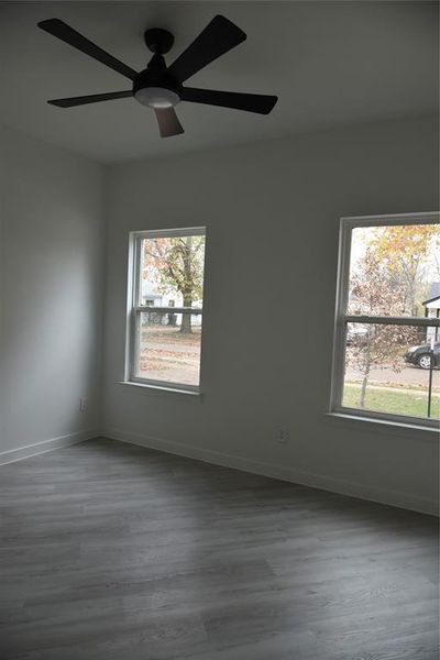 Spare room featuring light hardwood / wood-style floors, a wealth of natural light, and ceiling fan