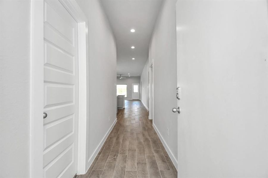 Greeted by a elegant glass front door (to be installed), the entrance beckons with high ceilings, adorned with elegant wood-look tile flooring and oversized baseboards. Representation of completed home with similar plan. Actual color and selections will vary.