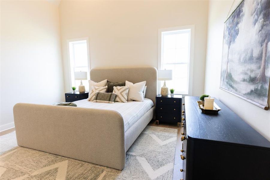 Bedroom with light-toned walls and wood-finish flooring