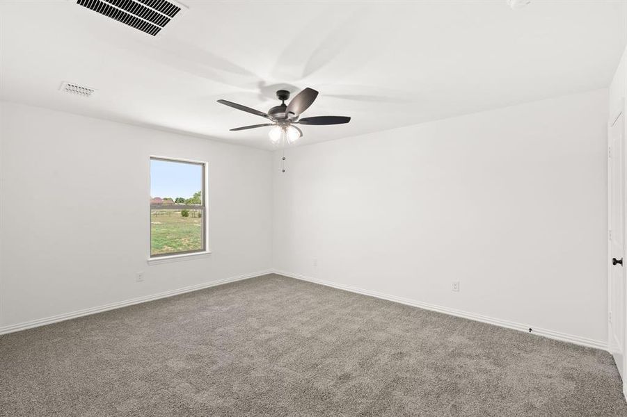Empty room featuring carpet flooring and ceiling fan Empty room featuring carpet flooring and ceiling fan
