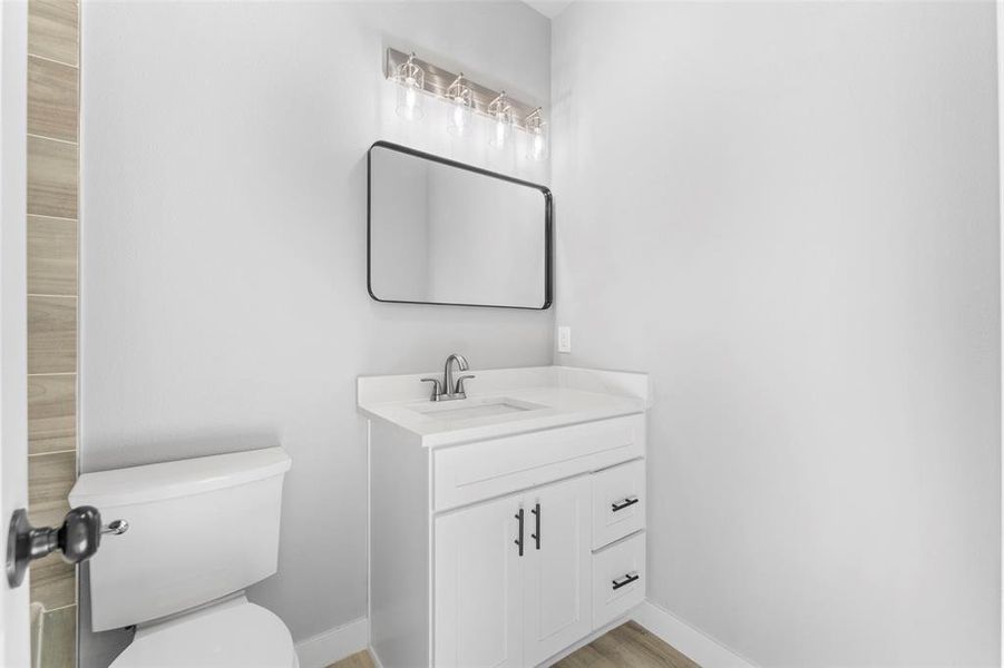 Half bathroom with vanity and light wood-style floors