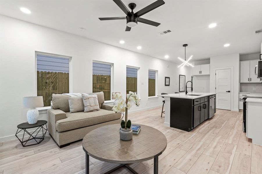 Living area featuring light wood-style flooring, recessed lighting, ceiling fan, baseboards, and a chandelier Living area featuring light wood-style flooring, recessed lighting, ceiling fan, baseboards, and a chandelier