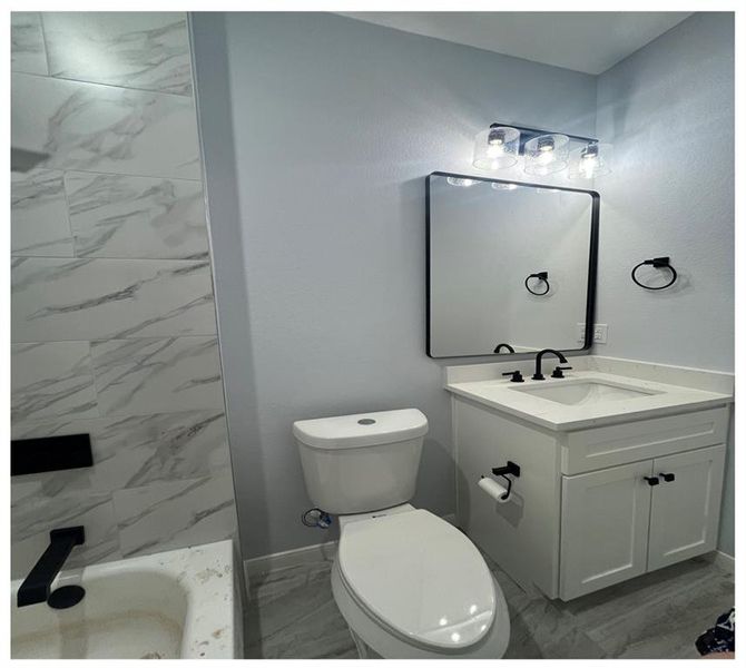 Full bathroom with vanity, plus walk in shower, and toilet