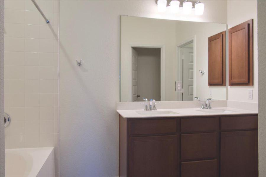 Double vanity sinks and bright lighting create a functional and stylish bathroom retreat.