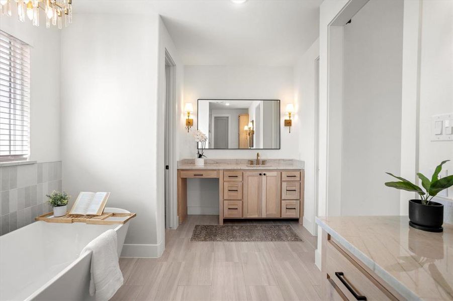 Bathroom featuring a chandelier, hardwood / wood-style floors, vanity, and a bath