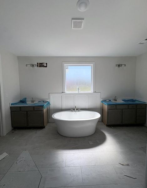 Freestanding bathtub, dual vanities with integrated sinks, and tiled flooring Freestanding bathtub, dual vanities with integrated sinks, and tiled flooring