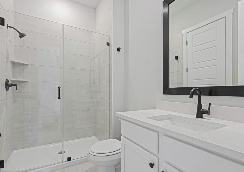 The third bathroom has a sprawling vanity and glass, walk-in shower.