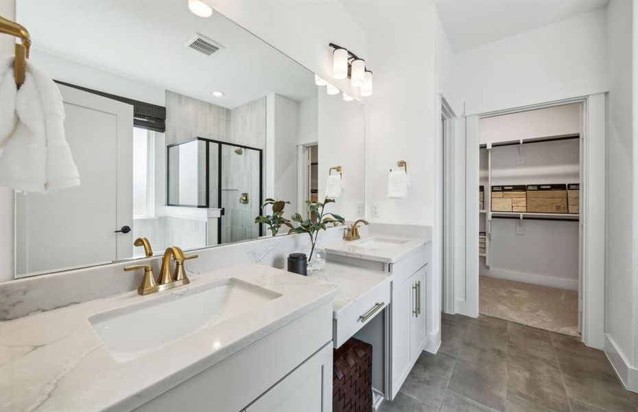 Modern owner's bath with dual vanities and a spacious shower *Model representation