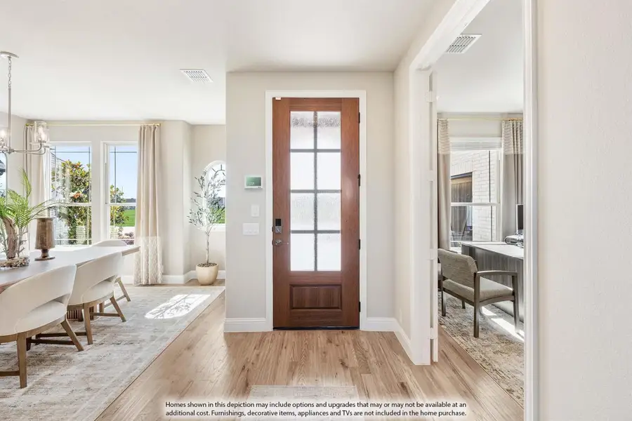 Entryway with wood front door featuring glass panels, hardwood floors, and open dining room view Entryway with wood front door featuring glass panels, hardwood floors, and open dining room view