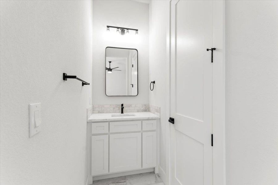 Bathroom featuring marble finish flooring and vanity Bathroom featuring marble finish flooring and vanity