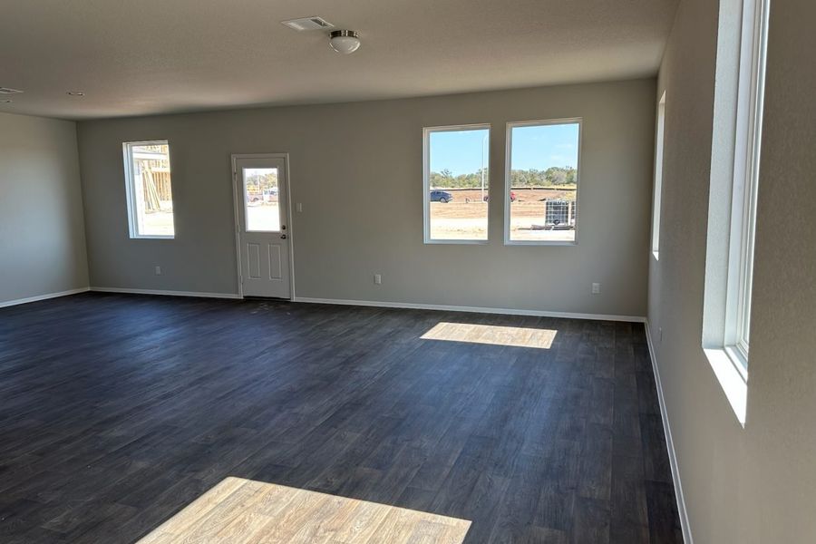 Image of home living and dining areas with wood-look floors, white walls, and windows Image of home living and dining areas with wood-look floors, white walls, and windows