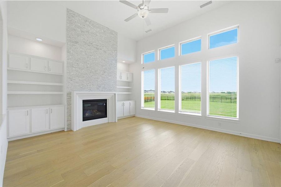 Living area featuring an accent fireplace wall with light-toned stone tile surround, a built-in electric fireplace, and a white wood mantel