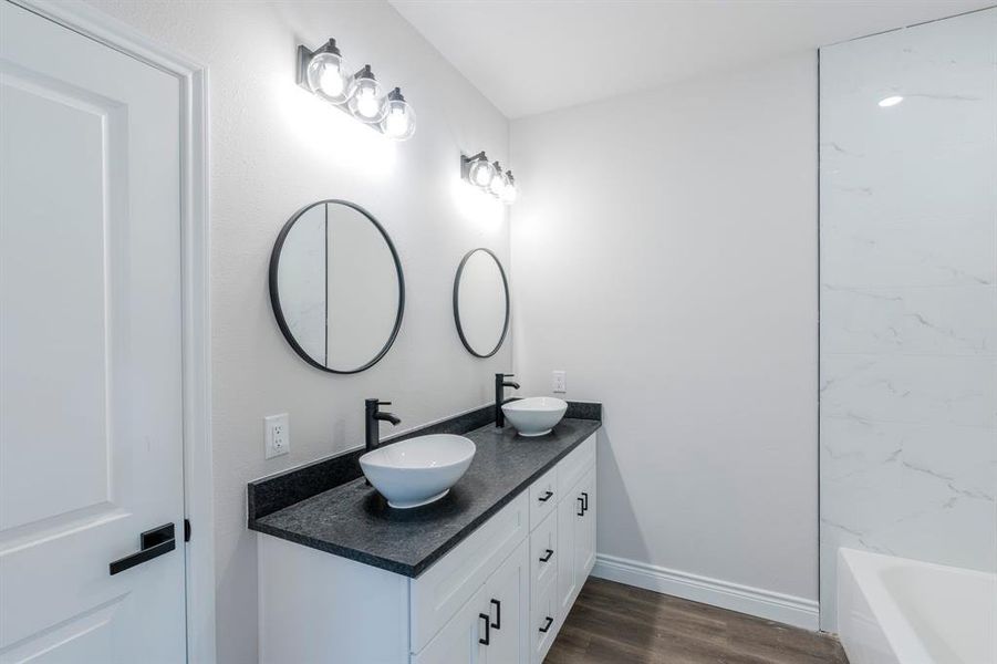 Bathroom featuring vanity, hardwood / wood-style flooring, and bathtub / shower combination