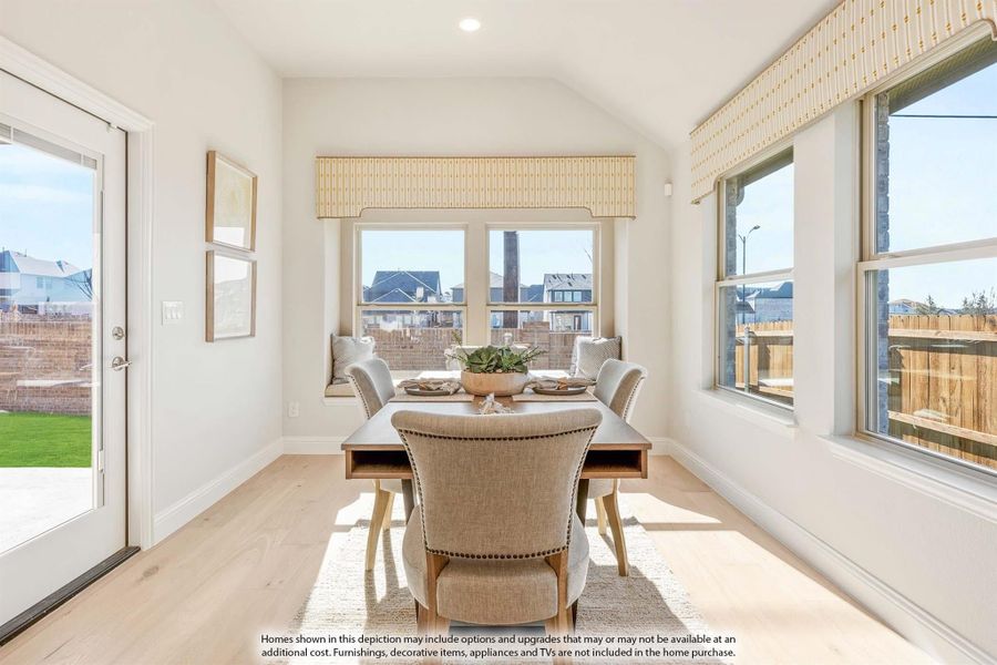 Bright dining nook with vaulted ceiling, wood table, upholstered chairs, window seat, and patio door Bright dining nook with vaulted ceiling, wood table, upholstered chairs, window seat, and patio door