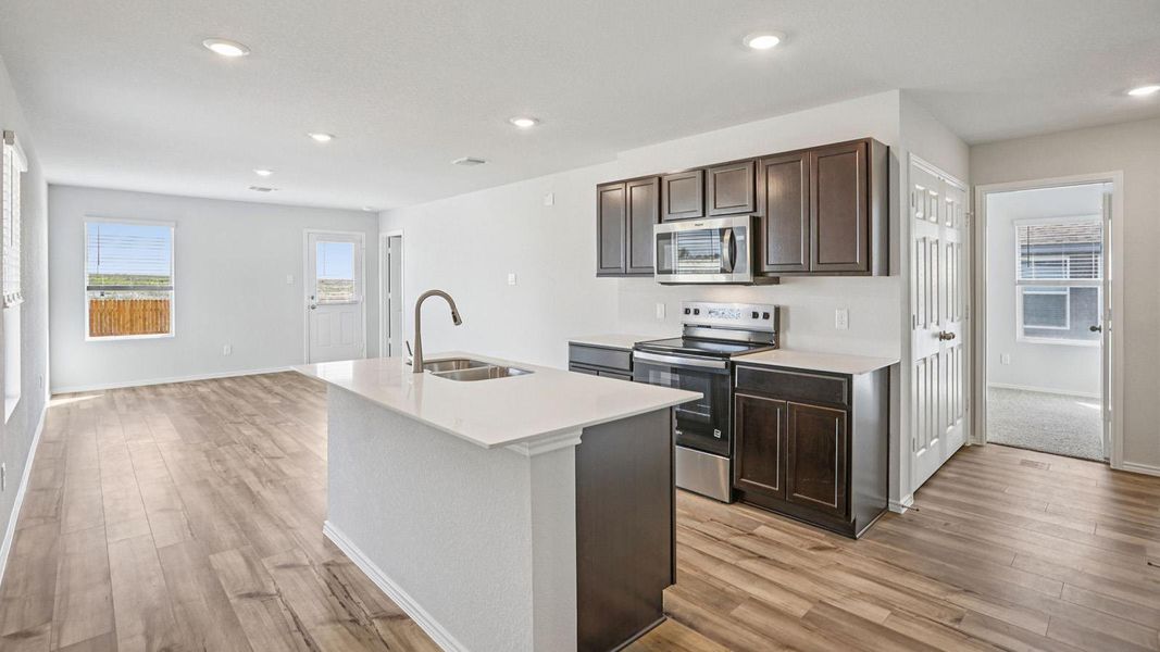 A contemporary kitchen offers a central island, rich cabinetry, and sleek stainless steel appliances. A contemporary kitchen offers a central island, rich cabinetry, and sleek stainless steel appliances.