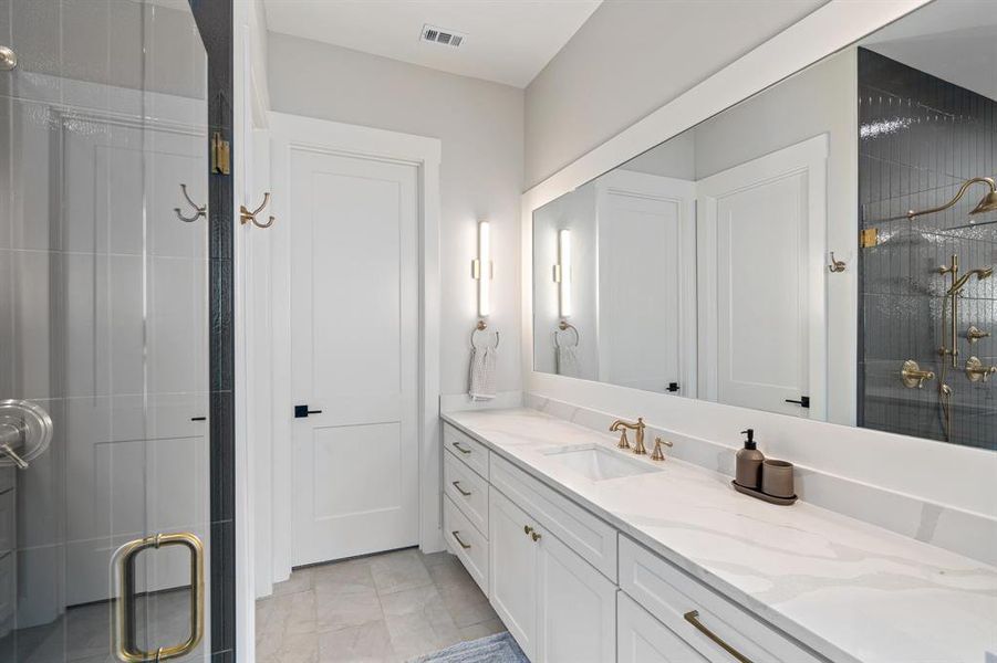 Bathroom featuring tile floors, a shower with shower door, and vanity