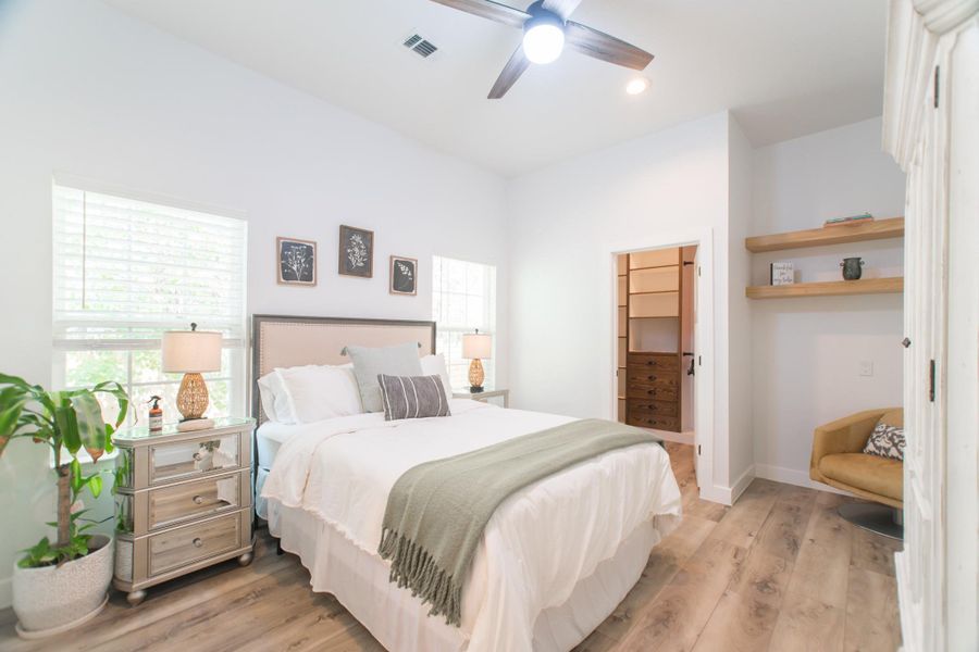 The second bedroom features hardwood flooring, recessed lighting, a ceiling fan, and large windows. The second bedroom features hardwood flooring, recessed lighting, a ceiling fan, and large windows.