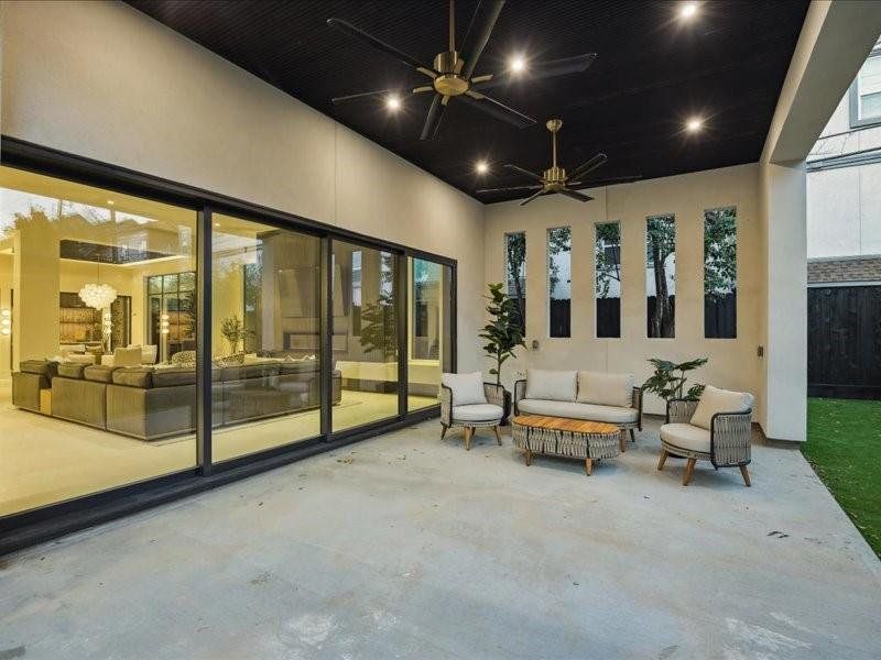 Walls of sliding glass doors retract fully, creating a seamless flow between the interior and the beautiful covered patio for effortless indoor-outdoor living.