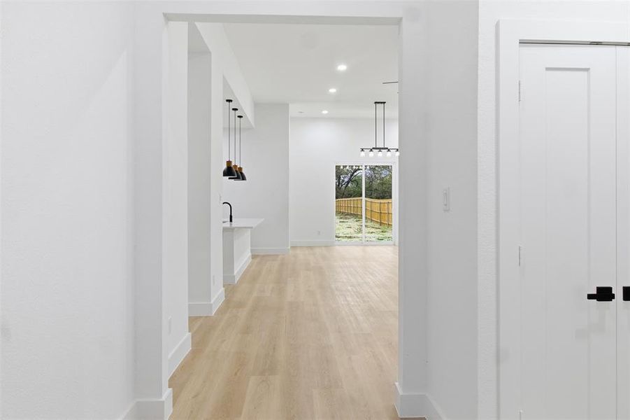 Hall featuring light wood finished floors and recessed lighting