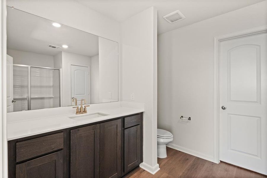 Full bathroom featuring a shower stall, vanity, dark wood-style flooring, and recessed lighting