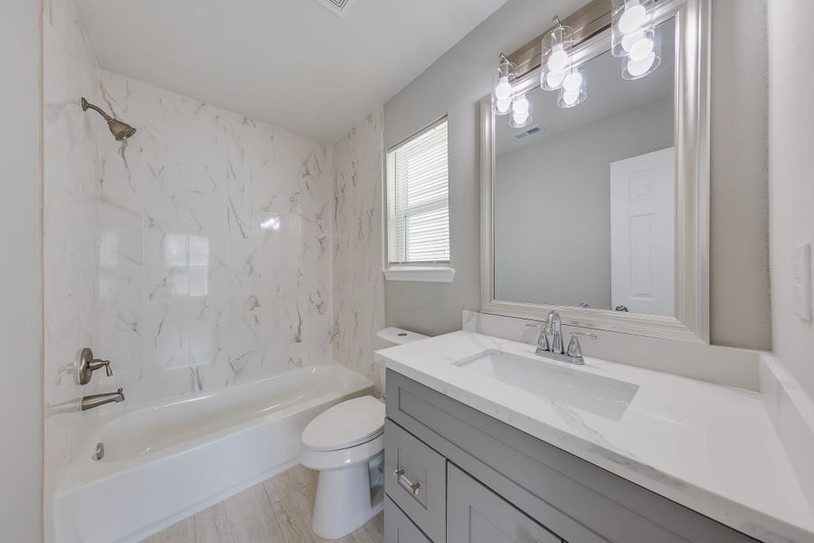 This bright, clean bathroom features a versatile shower-tub combo, perfectly blending modern style with everyday functionality for your needs.