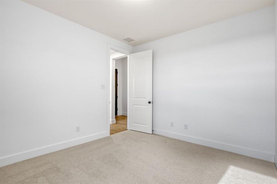 Empty room featuring light carpet and baseboards