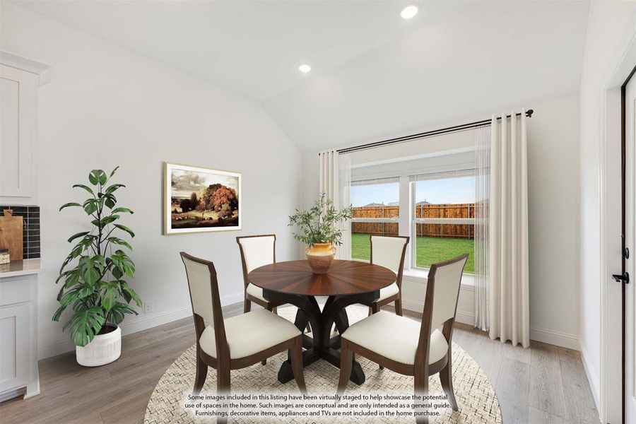 Dining area with round wood table, four chairs, vaulted ceiling, and large window overlooking backyard Dining area with round wood table, four chairs, vaulted ceiling, and large window overlooking backyard