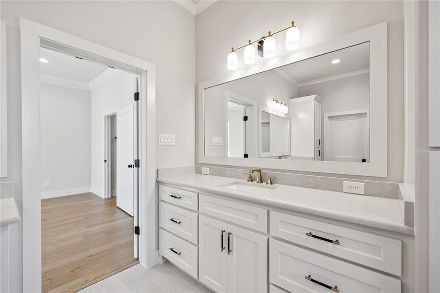 Bathroom with vanity, ornamental molding, light wood-style floors, and recessed lighting