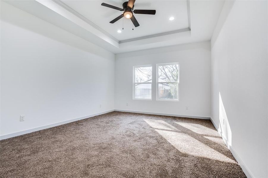 Unfurnished room featuring a ceiling fan, a tray ceiling, recessed lighting, carpet flooring, and baseboards