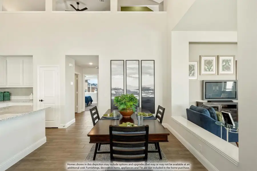 Open dining area with high ceilings, dark wood table, and wood-look floors adjacent to kitchen and living room