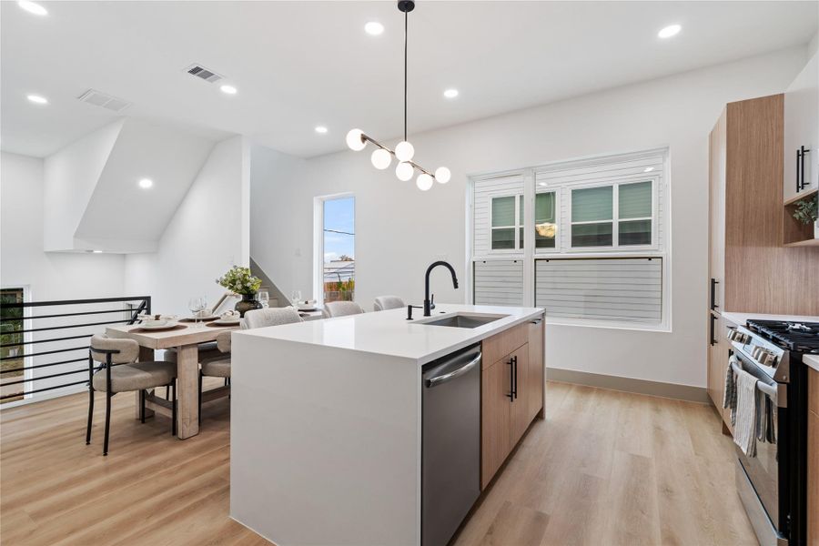 Clean lines and clever design come together in this stunning galley-style kitchen, where flat-front cabinets, matte black hardware, and a gas range elevate the everyday. With open shelving and a waterfall island, this space is equal parts function and finesse—ready to handle everything from weeknight dinners to weekend brunches.
