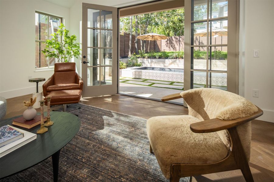 French doors open directly to a private backyard patio with a pool. French doors open directly to a private backyard patio with a pool.