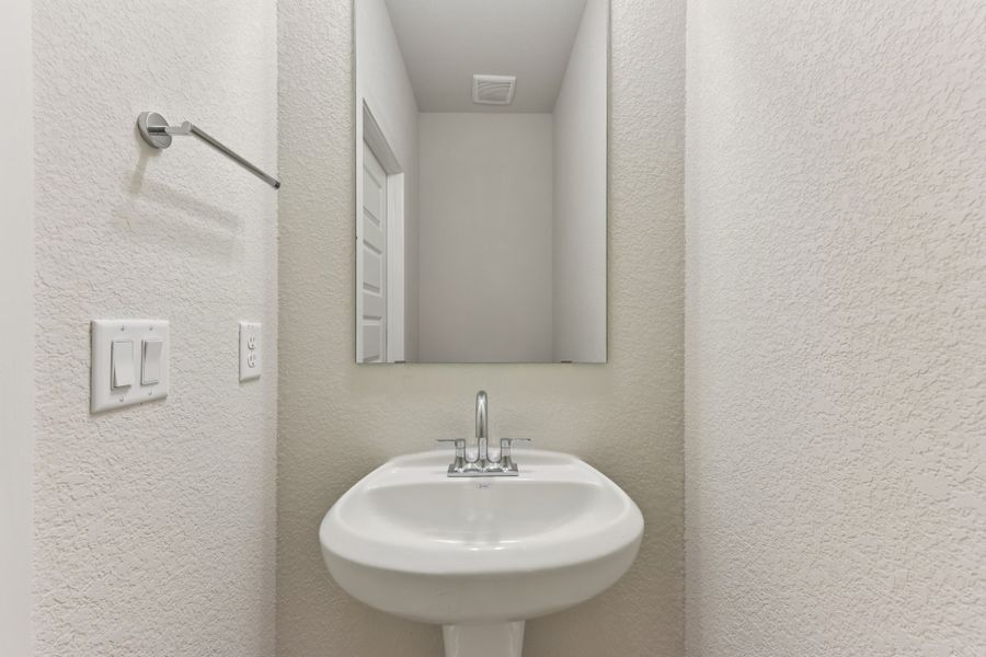 A bathroom with a sink and mirror. A bathroom with a sink and mirror.