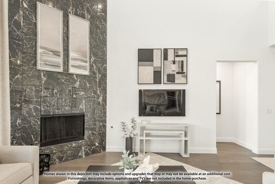 Living room with floor-to-ceiling dark marble fireplace surround, high ceilings, and hardwood floors Living room with floor-to-ceiling dark marble fireplace surround, high ceilings, and hardwood floors