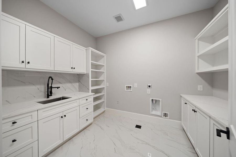 Utility room with built-in cabinetry, quartz folding counter, and open shelving for organized storage and hanging space. Utility room with built-in cabinetry, quartz folding counter, and open shelving for organized storage and hanging space.