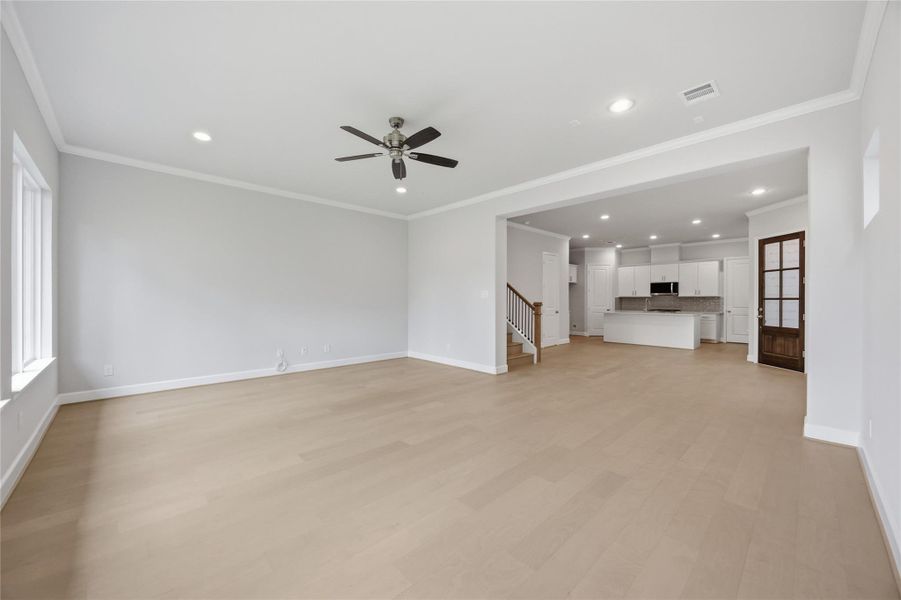 Effortless Flow: The spacious living room, with standard wood flooring, seamlessly connects to the dining area, creating a welcoming space designed for comfort and entertaining.