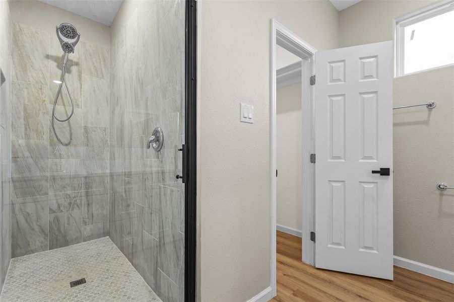 Bathroom with a stall shower and wood finished floors