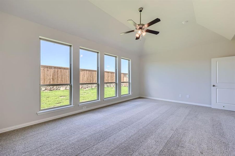 Primary bedroom with vaulted ceiling and ceiling fan