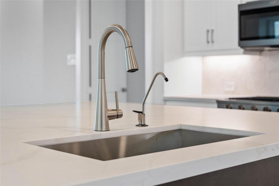 Moen Sleek - Stainless Steel pull-down faucet offers versatility and contemporary design, complemented by a convenient separate filtered water dispenser faucet.