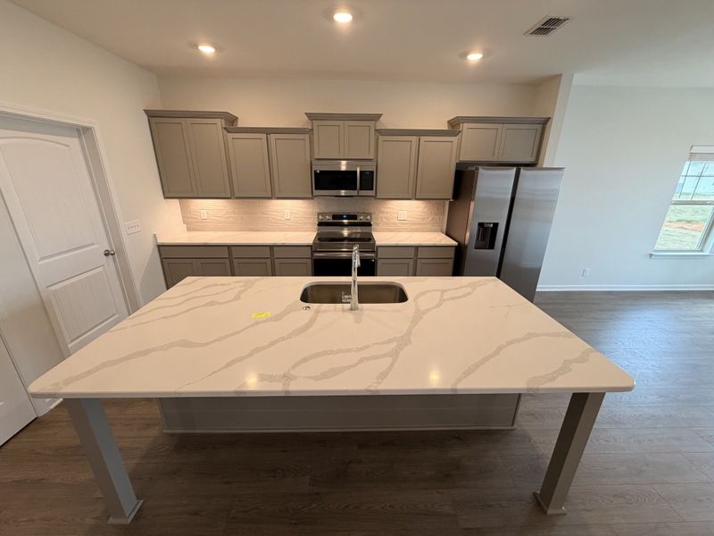 Center piece of the kitchen is it`s Beautiful Quartz topped Island! Subway tiled backsplash is even included on this home!