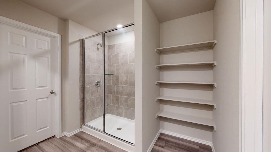 Bathroom featuring light wood-style flooring and a stall shower