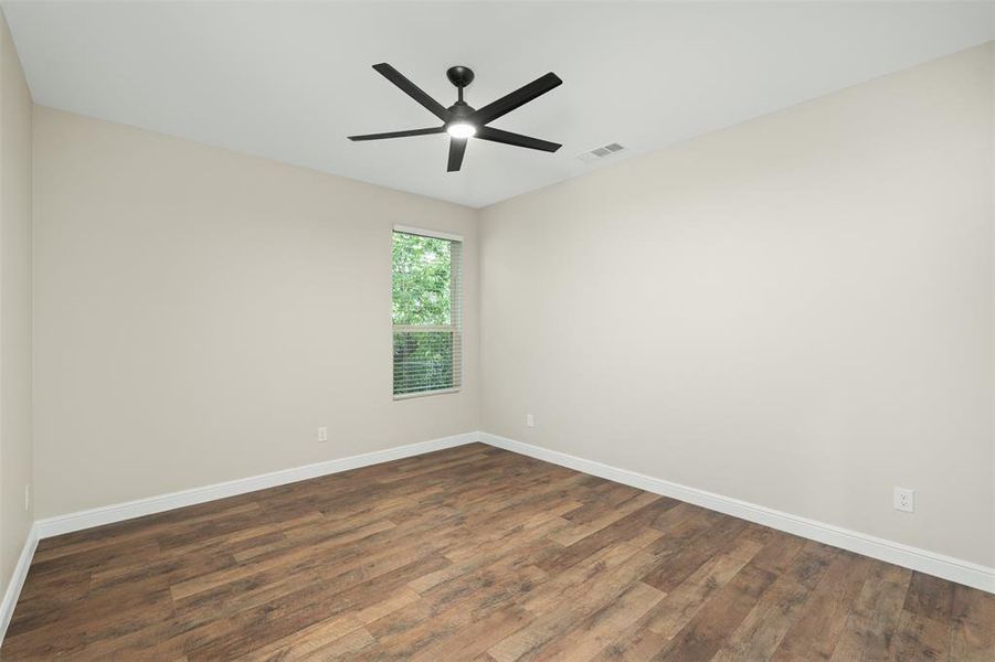 Unfurnished room with dark wood-style floors and ceiling fan